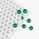 Translucent green 2.6mL hemisphere gummies beside the 202-cavity silicone mold