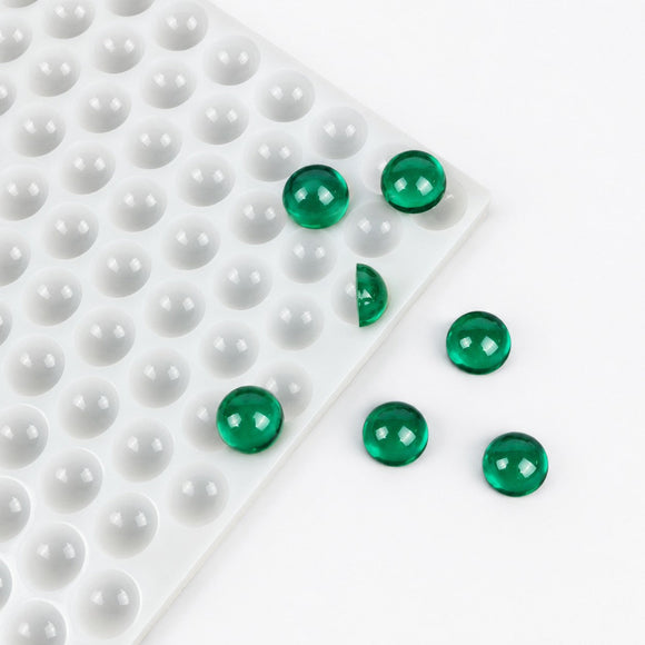 Translucent green 2.6mL hemisphere gummies beside the 202-cavity silicone mold